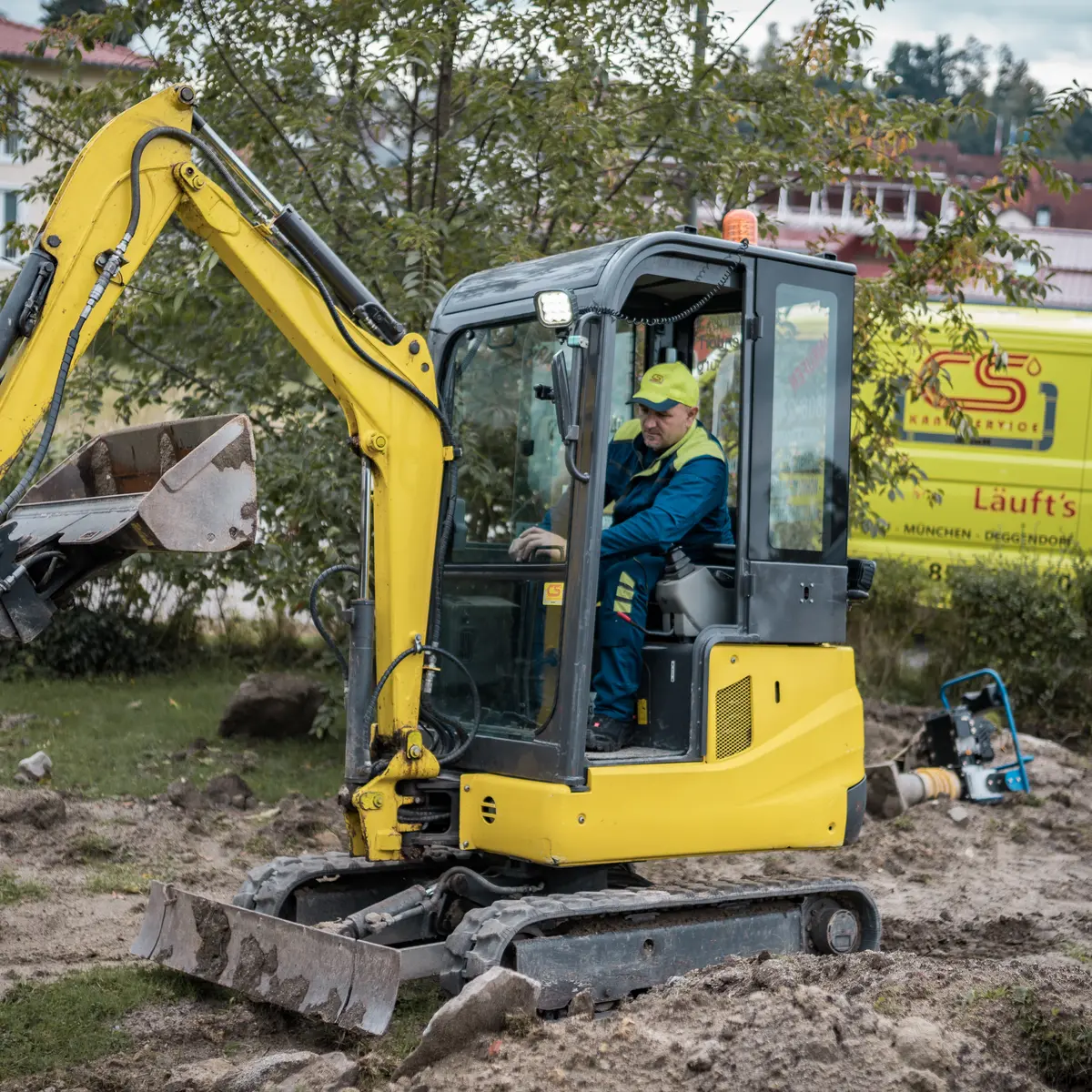 Monteur der Kanalservice CS GmbH mit Schubkarre an einem offenen Leitungsgraben