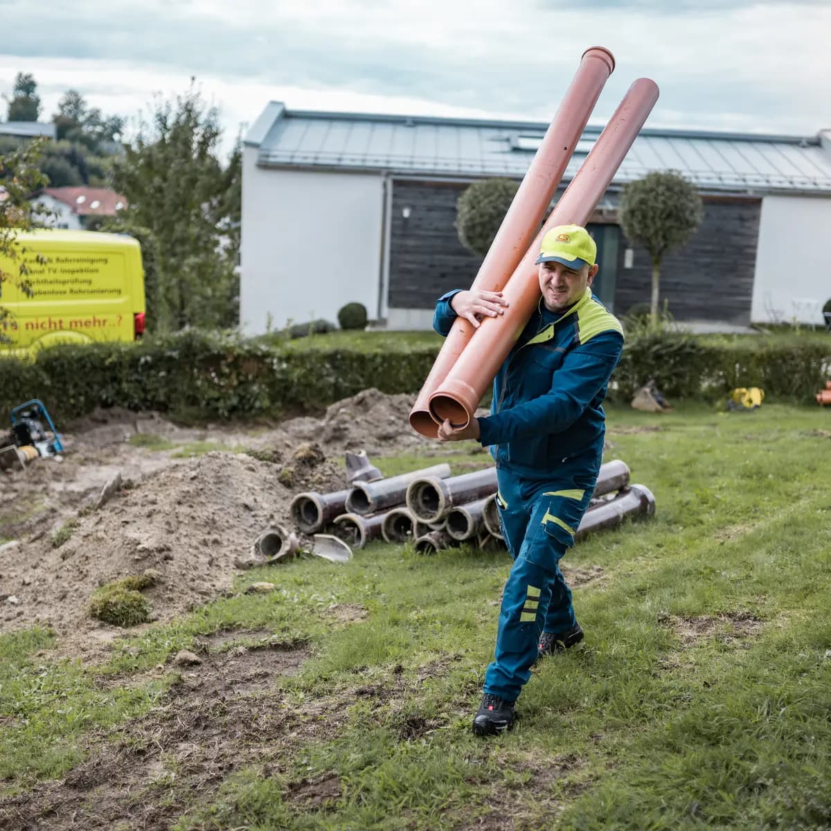Monteur der Kanalservice CS GmbH trägt Kanalrohre zur Baustelle