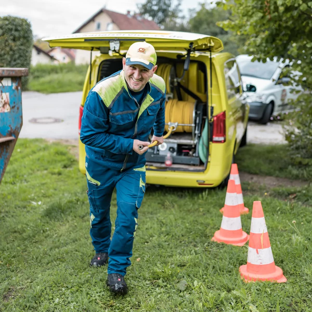 Monteur der Kanalservice CS GmbH zieht den Reinigungsschlauch aus dem Servicefahrzeug